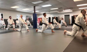 Adult Karate students warming up with stretching exercises at Nishime Martial Arts